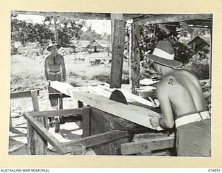 LAE, NEW GUINEA. 1944-11-11. NX130492 WARRANT OFFICER II, J. KEELAND (1) AND N391388 PRIVATE F.D. MOORE (2) OF THE 112TH CONVALESCENT DEPOT OPERATING THE UNIT SAWMILL WHERE ALL THE TIMBER USED IN ..