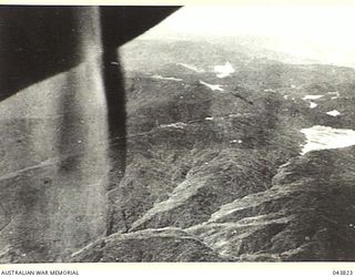 NEW GUINEA, 1942-08. THE COUNTRY SOUTH OF KOKODO, TAKEN FROM A HEIGHT OF 25,000 FEET, SHOWING A TANGLE OF MOUNTAINS AND GORGES COVERED WITH DENSE AND HUMID JUNGLE AND RAIN FOREST. (PUBLISHED IN ..