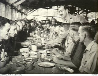 PORT MORESBY, PAPUA. 1942-12-25. THE COMMANDING OFFICER OF NO. 30 (BEAUFIGHTER) SQUADRON RAAF, WING COMMANDER C. P. GLASSCOCK, SERVES HIS OWN AIRMEN AT THEIR CHRISTMAS DINNER. SHORTLY AFTER THIS ..