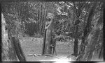 Boy next to drum, with carving of ancestral spirit