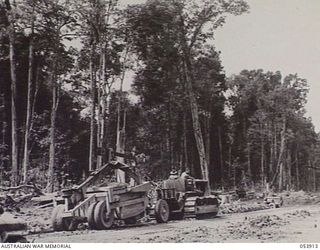 TERAPO, NEW GUINEA. 1943-06-30. TRACTOR AND 6 CUBIC YARD "CARRY-ALL" SCOOP OF THE ROYAL AUSTRALIAN ENGINEERS, 11TH AUSTRALIAN DIVISION WORKING ON THE BULLDOG-WAU ROAD