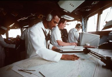 A quartermaster working on the bridge of the amphibious assault ship USS GUAM (LPH-9) uses a drafting machine as he plots the ship's course. The GUAM is returning to Naval Station, Norfolk, Va., following its deployment to the Persian Gulf region for Operation Desert Shield and Operation Desert Storm