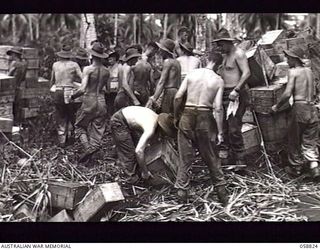 LANGEMAK BAY, NEW GUINEA. 1943-10-20. TROOPS OF THE AUSTRALIAN ARMY SERVICE CORPS, 9TH AUSTRALIAN DIVISION STACKING BOXES OF STORES AT THE BEACH HEAD