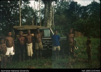 People standing next to ANU jeep