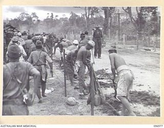 TOROKINA, BOUGAINVILLE. 1945-09-23. JAPANESE TROOPS FROM NAURU ISLAND DIGGING DRAINS UNDER THE SUPERVISION OF TROOPS OF 9TH INFANTRY BATTALION, AT THE CHOP CHOP TRAIL CONCENTRATION CAMP. THE ..