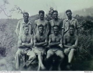 GOODENOUGH ISLAND, D'ENTRECASTEAUX ISLANDS, PAPUA. 1945. GROUP PORTRAIT OF MEMBERS OF NO. 5 AIRFIELD CONSTRUCTION SQUADRON (ACS), RAAF. SEATED LEFT, 49941 Corporal Leslie Francis Hesketh