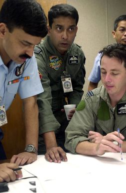 Squadron Leaders, B.S. Kanwar, (left), Indian Air Force, and Shaheed Al-mamun, Bangladesh Air Force along with Flight Lieutenant Martyn Silver, (right), Royal Australian Air Force exchanges ideas about flightline activities in preparation for PACIFIC AIRLIFT RALLY 2001 on Andersen AFB, Guam. PACIFIC AIRLIFT RALLY (PAR) is a PACAF-sponsored Military Airlift symposium for countries in the pacific region. PAR, held every two years and hosted by a pacific nation, this year Guam is the host nation with the symposium staging out of Andersen AFB. The symposium includes informational seminars with area of expertise briefings, a Command Post Exercise (CPX) which addresses military airlift support...