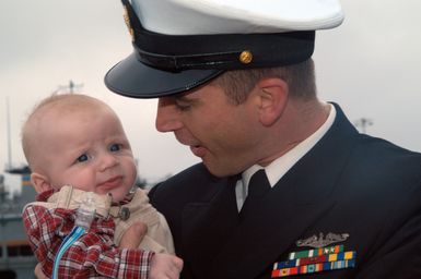 BREMERTON, Wash. (Oct. 28, 2006) CHIEF Fire Control Technician Drew Collins, assigned to Los Angeles-class nuclear-powered fast-attack submarine USS HONOLULU (SSN 718), holds his son 3-month-old son, for the first time after arriving at Naval Base Kitsap. HONOLULU, formerly home ported in Hawaii, moved to Bremerton for decommissioning. U.S. Navy photo by Mass Communication SPECIALIST 3rd Class Angela Grube (Released)