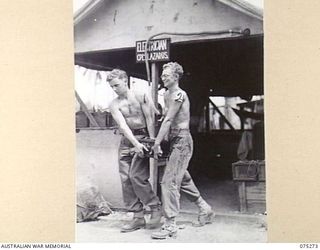 MADANG, NEW GUINEA. 1944-08-15. NX131985 CORPORAL W.W. LAZARUS, NON COMMISSIONED OFFICER- IN- CHARGE, ELECTRICAL SECTION WORKSHOP, 165TH GENERAL TRANSPORT COMPANY (2) ASSISTED BY NX125251 PRIVATE ..