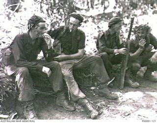 THE SOLOMON ISLANDS, 1945-04-24/27. FOUR AUSTRALIAN SOLDIERS RESTING DURING A PATROL ON BOUGAINVILLE ISLAND. (RNZAF OFFICIAL PHOTOGRAPH.)
