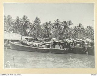 LABU, NEW GUINEA. 1944-10-03. SOME OF THE CRAFT OF THE 1ST WATERCRAFT WORKSHOPS, TIED UP AT THE UNIT WHARF AM1573 (LEFT) WAS REBUILT FOR THE GOC NEW GUINEA FORCE. THE CANVAS AWNING WAS REMOVED AND ..