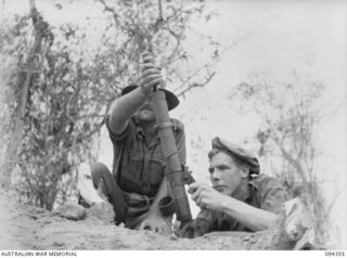 ULUNKOHOITU, NEW GUINEA, 1945-07-18. PTE J. PLUNKETT (1) AND PTE K.T. BIDDLE (2) MEMBERS OF 8 PLATOON, A COMPANY, 2/6 INFANTRY BATTALION, FIRING A 2-INCH MORTAR TO RETURN FIRE FROM A FRESHLY ..