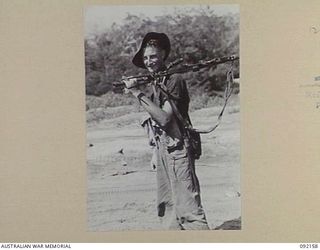 WEWAK AREA, NEW GUINEA. 1945-05-13. PRIVATE R.O. FISHER, 2/8 INFANTRY BATTALION, MARCHING ALONG THE BEACH NEAR WEWAK ON THE WAY TO RELIEVE THE 2/4 INFANTRY BATTALION