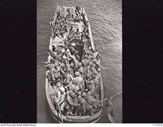 NAURU ISLAND. 1945-09-16. JAPANESE POWS ABOARD A BARGE WHICH IS TAKING THEM OUT TO THE RAN VESSEL WHICH IS TO EVACUATE THEM TO BOUGAINVILLE SOON AFTER THE ISLAND WAS OCCUPIED BY TROOPS OF THE ..