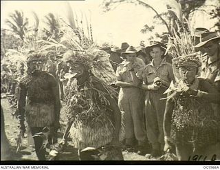 MADANG, NEW GUINEA. 1944-12-25. RAAF PERSONNEL ENJOYING THE UNUSUAL ENTERTAINMENT OF A NATIVE SING-SING ON CHRISTMAS DAY IN NEW GUINEA. ALL NEIGHBOURING TRIBES WERE REPRESENTED. THE UNUSUAL ..