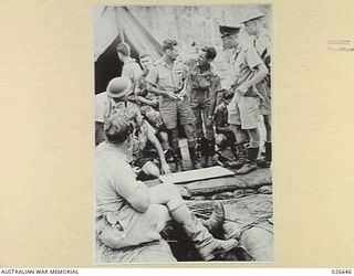 MILNE BAY, PAPUA. 1942-09. LOCKHEED HUDSON BOMBER CREWS OF THE RAAF BEING BRIEFED OUTSIDE THE SQUADRON OPERATIONS TENT BEFORE GOING OUT ON A MISSION