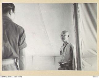 CAPE WOM, NEW GUINEA. 1945-10-19. LIEUTENANT TAZAKI, OF THE JAPANESE ARMY, BEING QUESTIONED AT HEADQUARTERS 6 DIVISION BY THE WEWAK WAR CRIMES COMMISSION, WHICH IS TAKING SUMMARIES OF EVIDENCE FOR ..