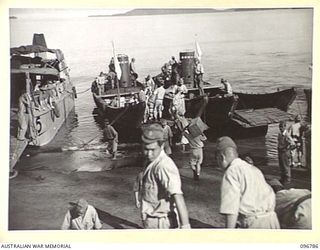 SORAKEN, BOUGAINVILLE, 1945-09-20. A JAPANESE WORKING PARTY LOADING RATIONS ONTO JAPANESE BARGES FOR TRANSPORT AND DISTRIBUTION TO TROOPS IN THE BUKA AREA, AS ARRANGED BY THE AUSTRALIAN SURRENDER ..