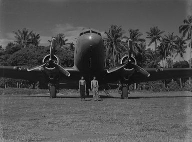 [Portrait of two young Pacific Island men in front of a plane]