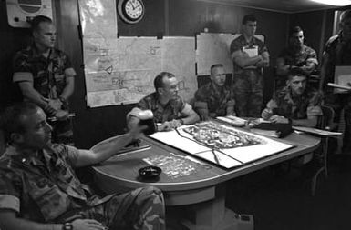 Officers of the 22nd Marine Expeditionary Unit (22nd MEU) gather in the MEU commander's office aboard the amphibious assault ship USS SAIPAN (LHA 2) for a briefing on the situation in and around Monrovia, Liberia. The SAIPAN is on station off the coast of Liberia for Operation Sharp Edge