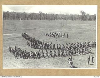 WONDECLA, QLD. 1944-04-15. MEMBERS OF THE 2/1ST INFANTRY BATTALION MARCHING OFF THE HERBERTON RACECOURSE AFTER A PARADE. THE COMMANDING OFFICER NX163 LIEUTENANT COLONEL P.A. CULLEN, DSO., (1) CAN ..