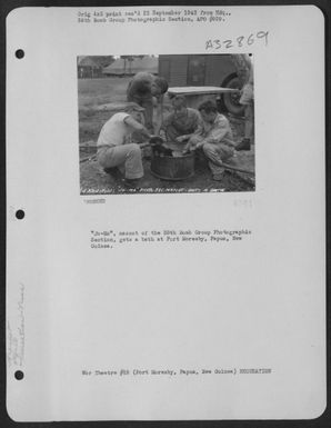 "Jo-Mo," mascot of the 38th Bomb Group Photographic Section, gets a bath at Port Moresby, Papua, New Guinea. (U.S. Air Force Number 3A32869)