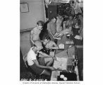 Scientists, including Dr. L. R. Donaldson, working in laboratory aboard the USS CHILTON, 1947