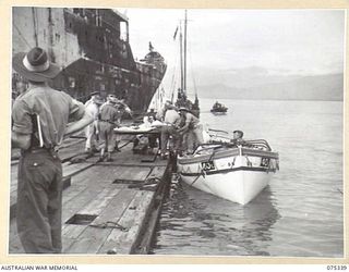 LAE, NEW GUINEA. 1944-08-18. PATIENTS OF THE 2/7TH GENERAL HOSPITAL BEING PLACED ABOARD LIFEBOATS FOR TRANSPORT OUT TO THE 2/1ST HOSPITAL SHIP, "MANUNDA" WHICH IS MOORED IN THE STREAM SOME DISTANCE ..