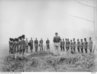 KIARIVU, NEW GUINEA, 1945-08-17. THE BURIAL CEREMONY OF A NATIVE SOLDIER OF 2 NEW GUINEA INFANTRY BATTALION WHO DIED OF WOUNDS SUFFERED IN THE INITIAL ATTACK ON KIARIVU. A GUARD OF HONOUR DRAWN ..