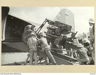 1943-06-25. NEW GUINEA. A U.S. ANTI-AIRCRAFT UNIT LOADS A 40MM BOFORS GUN INTO A DOUGLAS C47 DAKOTA TRANSPORT PLANE