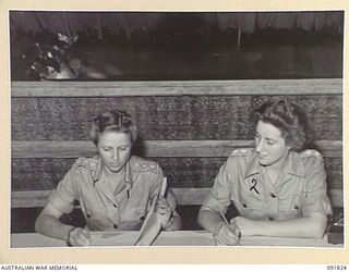 LAE, NEW GUINEA. 1945-05-15. CAPTAIN L. CRANE, COMMANDANT, AUSTRALIAN WOMEN'S ARMY SERVICE HEADQUARTERS (1), DISCUSSING ADMINISTRATIVE MATTERS WITH LIEUTENANT M. BEARD, ASSISTANT COMMANDANT (2), AT ..