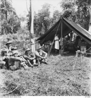 KILIGIA, NEW GUINEA. 1944-03-13. MEMBERS OF THE 2/14TH FIELD REGIMENT, AWAIT TREATMENT OUTSIDE THE MOBILE DENTAL SURGERY OF "E" SECTION, 2/5TH DENTAL UNIT. THE OBJECT OF THIS UNIT IS TO PROVIDE ..