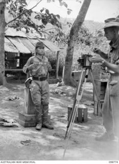 RABAUL, NEW BRITAIN. 1945-11-15. SERGEANT R. RICE, OFFICIAL PHOTOGRAPHER, MILITARY HISTORY SECTION, HEADQUARTERS 11 DIVISION, TAKING PHOTOGRAPHS (FRONT AND PROFILE) OF SUSPECTED JAPANESE WAR ..