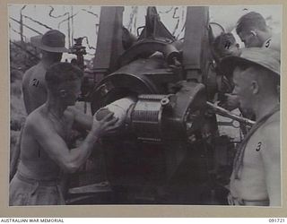 HAWAIN, WEWAK AREA, NEW GUINEA. 1945-05-09. A 2/3 FIELD REGIMENT GUN CREW MEMBER LOADING A 32-LB CORDITE CHARGE INTO A "LONG TOM" 155MM GUN DURING THE ATTACH AGAINST THE MAIN JAPANESE FORTRESS AT ..
