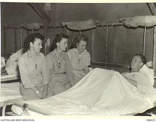 FINSCHHAFEN, NEW GUINEA. 1945-04-04. AMERICAN NURSES LIEUTENANT ZIMMERMAN, (1), LIEUTENANT FARRADAY, (2), AND LIEUTENANT HAGERTY, (3), SPEAK WITH LEADING AIRCRAFTMAN FRASER, 17 STORES UNIT RAAF, IN ..