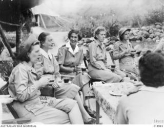 1943-06-10. NEW GUINEA. AT AN AUSTRALIAN GENERAL HOSPITAL IN NEW GUINEA. AMERICAN NURSES HAVE AFTERNOON TEA WITH AUSTRALIAN NURSES. LEFT TO RIGHT MISS G. ANDERSON OF MINNESSOTA, SISTER E. MILBURN ..