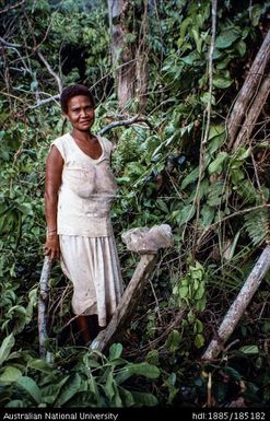 Woman by 'Bird stone' balanced on an upright slab 'planted' by an ancestor, near Lauhina