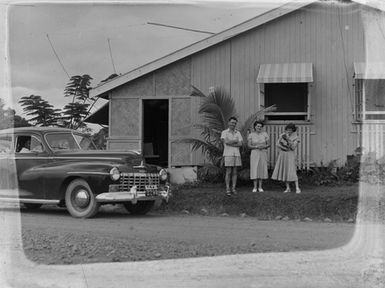 [Portrait of three people in front of house in Pacific Islands]