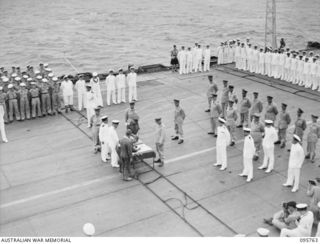 AT SEA OFF RABAUL, NEW BRITAIN. 1945-09-06. THE SURRENDER CEREMONY ON BOARD THE AIRCRAFT CARRIER HMS GLORY, SHOWING GENERAL H. IMAMURA, COMMANDER EIGHTH AREA ARMY, SIGNING THE INSTRUMENT OF ..