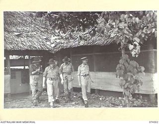 MADANG, NEW GUINEA. 1944-07-27. MEMBERS OF THE EMPIRE PARLIAMENTARY DELEGATION LEAVING THE NEW GUINEA FORCE BATTLE ROOM AFTER VIEWING THE RECORDS OF THE NEW GUINEA CAMPAIGN. IDENTIFIED PERSONNEL ..