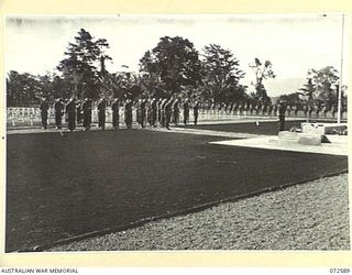 LAE, NEW GUINEA. 1944-04-23. THE GUARD OF HONOUR DRAWN FROM THE 29TH INFANTRY BRIGADE STAND WITH REVERSED ARMS DURING THE DEDICATION CEREMONY. THE CEMETERY WAS DEDICATED BY LIEUTENANT-GENERAL SIR ..