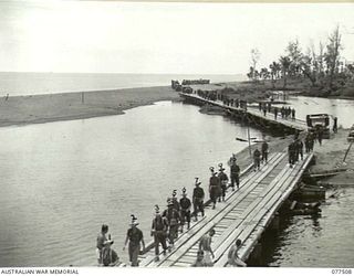 BOUGAINVILLE ISLAND. 1944-12-06. TROOPS OF A COMPANY, 15TH INFANTRY BATTALION WALKING ACROSS THE BRIDGE OVER THE TOROKINA RIVER AS THEY PROCEED TO THE FORWARD AREAS TO RELIEVE PERSONNEL OF THE 1ST ..