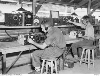 Lae, New Guinea. 1944-06-09. NX97786 Craftsman G.S. Neal, on the left, and QX48074 Craftsman R.B. Keogh repairing No 11 Australian Wireless sets at the 2/7th Advanced Workshop