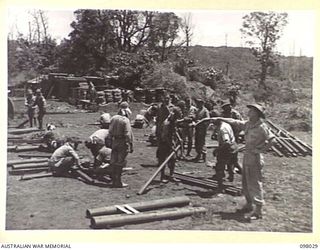 RABAUL, NEW BRITAIN. 1945-10-17. CAPTAIN G.F. FITZGERALD, 19 LINE OF COMMUNICATION SIGNALS, SUPERVISING JAPANESE SIGNAL CORPS PERSONNEL WHO ARE ASSEMBLING STEEL SIGNAL POLES