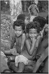 Young children gaze at camera, one wearing a necklace