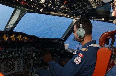 Royal Canadian Air Force (RCAF) Co-Pilot of the RCAF CP-140 Aurora (P-3 Orion) aircraft, 407th Maritime Patrol Squadron, 19th Wing, Comax, British Columbia, looks for signs of submarines after taking off from Andersen Air Force Base (AFB), Guam. The CP-140 Aurora (P-3 Orion) aircraft are used on long distance surveillance, interdiction missions and submarine warfare. The aircraft and crew are participating in the Joint exercise TANDEM THRUST 2003. The exercise is a joint endeavor including forces from the US, Canada, and Australia