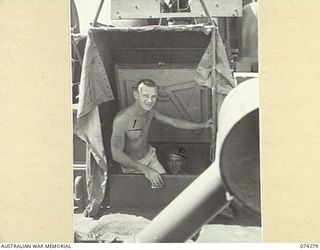 AT SEA. 1944-06-24. STOKER J. YATES, ROYAL AUSTRALIAN NAVY, COMING UP THROUGH THE FOREDECK HATCH ABOARD THE FAIRMILE ML431 (MOTOR LAUNCH) THE VESSEL PATROLS ALONG THE COAST BETWEEN HANSA BAY AND ..