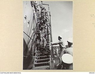 SIMPSON HARBOUR, RABAUL, NEW BRITAIN. 1945-09-10. TROOPS OF A COMPANY, 29/46 INFANTRY BATTALION, MOVING DOWN THE STARBOARD SIDE GANGWAY OF HMAS MANOORA, DURING THE LANDING OF THE FORCE TO OCCUPY ..