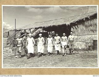 DUMPU, RAMU VALLEY, NEW GUINEA. 1943-11-24. SOME OF THE BAKERS OF THE 4TH AUSTRALIAN FIELD BAKERY LEAVING THE BAKEHOUSE ON THEIR WAY TO THEIR QUARTERS