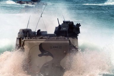 An AAVP7 assault amphibian vehicle (AAV) churns up sand and water as it follows two other AAVs off the beach and into the surf to return to their ship at the conclusion of Exercise RIMPAC 88. The AAVs are from Marine Corps Base, Twentynine Palms, Califor